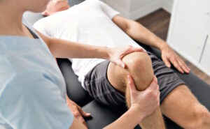 physical therapist holding a patients knee