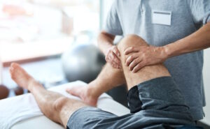 physical therapist stretching patients knee