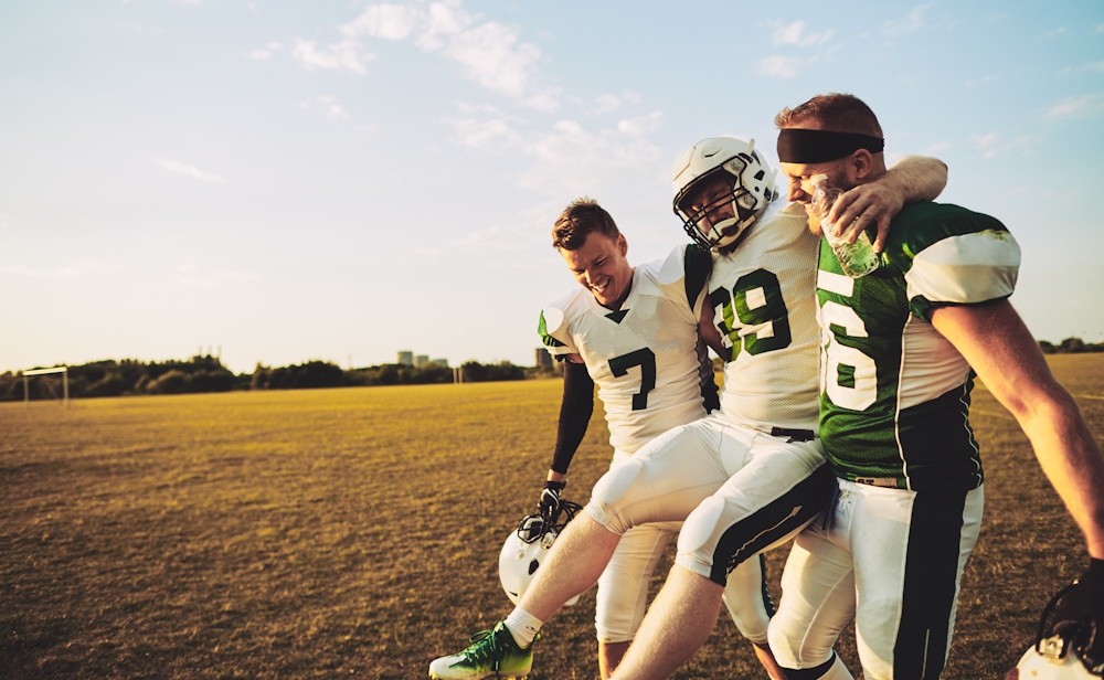 football player with injury walking off field