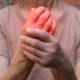 woman holding hurting arthritic hand