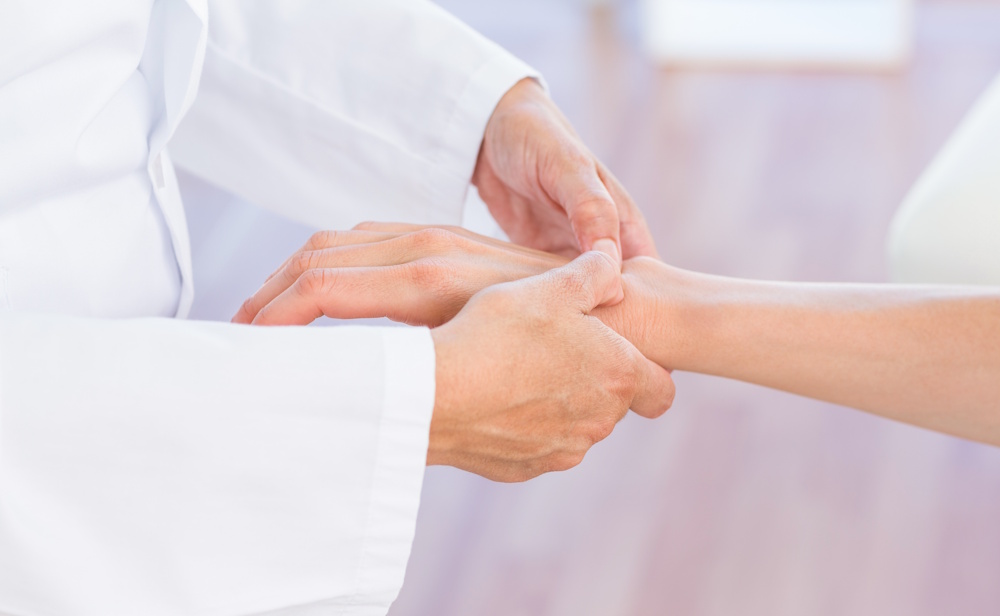 doctor evaluating patients wrist