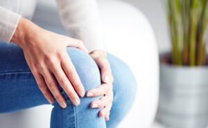 woman holding aching knee