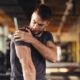 man holding injured shoulder