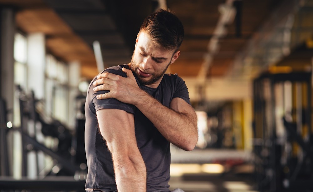 man holding injured shoulder