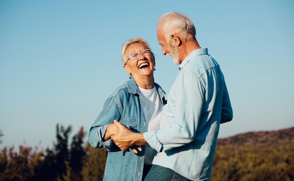 happy senior couple dancing outside