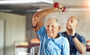 senior man exercising with physical therapist