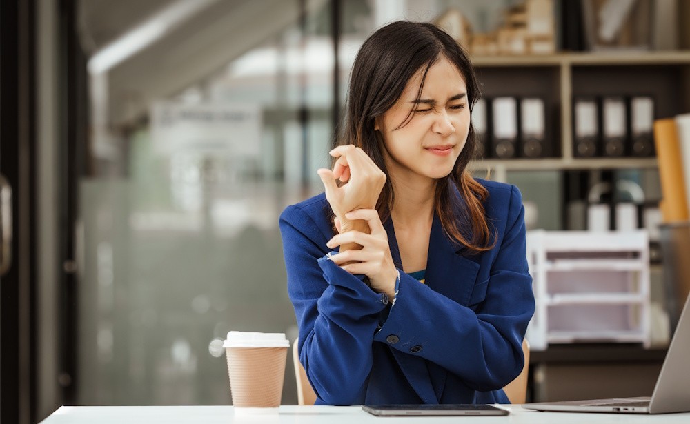 woman holding her wrist in pain