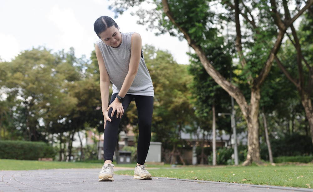 woman holding her knee in pain