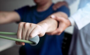 physical therapist stretching patients arm