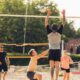 Adults playing sand volleyball