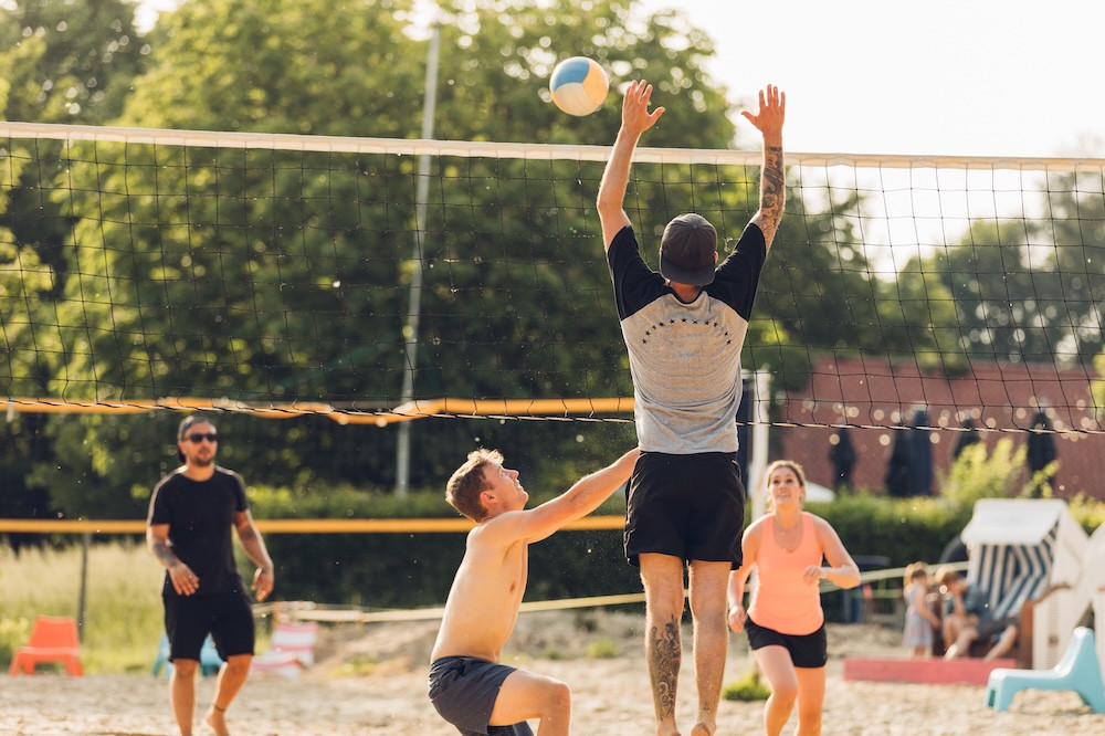 Adults playing sand volleyball