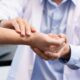 Medical concept a male doctor diagnosing a male patient’s wrist by pressing the wrist bone.
